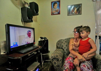 Familia cubana observando tv