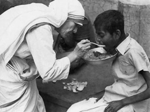 La Madre Teresa mientras alimenta a un niño pobre