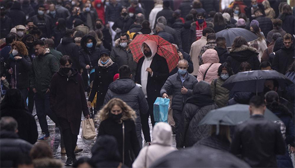 Transeúntes en Madrid, el 24 de diciembre de 2021. España, como otros países, atraviesa un repunte de los contagios mientras finaliza el año. Foto: AP.