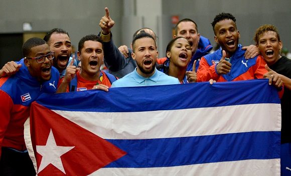El equipo cubano masculino de tenis de mesa celebra su oro junto a las damas.