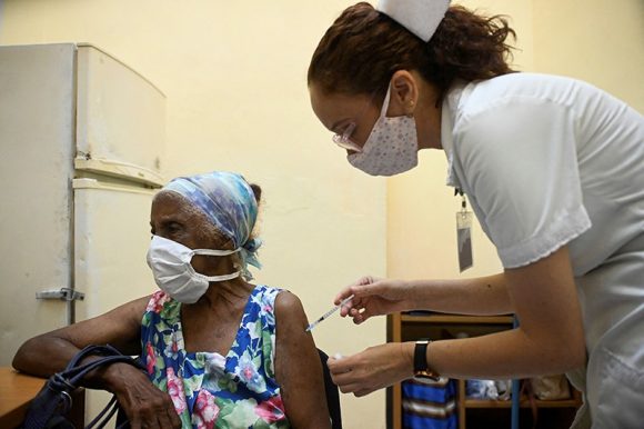 Trabajadora de la Salud vacuna a mujer adulto mayor con la vacuna Abdala, en agosto de 2021. Foto: AFP