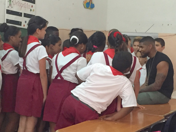 Usher conversa con niños cubanos