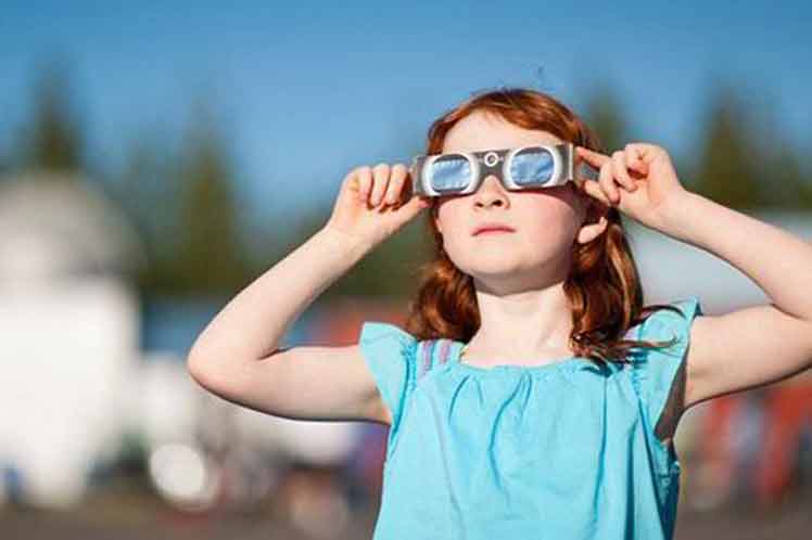 Una niña mira el eclipse solar