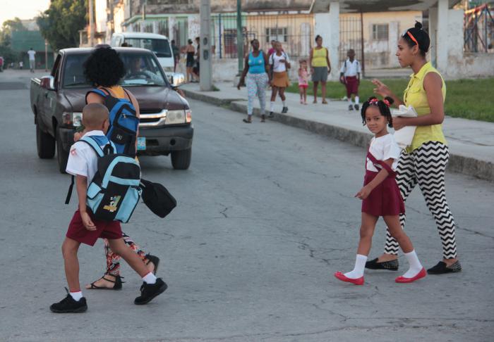 Niños cruzando calles con sus padres