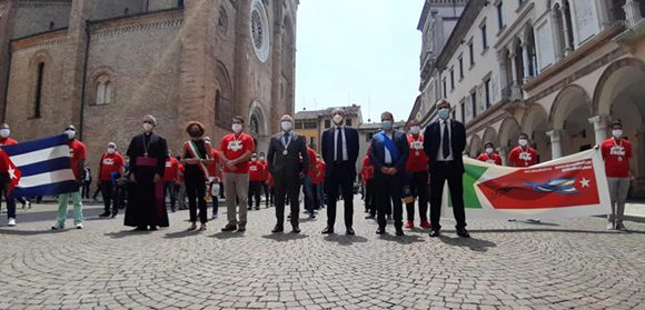 Grandes emociones se vivieron este sábado en la ciudad italiana de Crema, Italia, durante el acto organizado por sus autoridades para agradecer la ayuda brindada por colaboradores cubanos de la salud en la batalla librada en la región de Lombardía contra la COVID-19.  La céntrica Plaza del Duomo sirvió de escenario para el homenaje a los 52 integrantes de la brigada médica Henry Reeve que cumplieron la noble misión, junto a sus colegas italianos, durante dos meses.      Los 36 médicos, 15 enfermeros y un especialista en logística recibieron el reconocimiento en la explanada, puestos de pie, con mascarillas de protección facial y respetando la distancia de seguridad establecida para evitar el contagio.  Autoridades regionales y locales presidieron la actividad en la cual participaron, además, el embajador de Cuba en Italia, José Carlos Rodríguez, el cónsul general en Milán, Llanio González, y la presidenta de la Asociación Nacional de Amistad Italia-Cuba (Anaic), Irma Dioli.  Figuras centrales del homenaje fueron el secretario de Salud y Bienestar del gobierno de la región de Lombardía, Giulio Gallera; la alcaldesa de Crema, Stefanía Bonaldi y el embajador, quienes siguieron de cerca la labor de la brigada encabezada por el doctor Carlos Ricardo Pérez.  Asistieron también alcaldes y alcaldesas de localidades vecinas, representantes de las instituciones que conforman el gobierno municipal y del clero, además del numeroso público congregado más allá de las barreras de protección.  Con los himnos nacionales de Cuba e Italia comenzó la actividad en la cual el embajador agradeció la iniciativa, al tiempo que manifestó un reconocimiento especial para el personal sanitario italiano por el papel desempeñado en el enfrentamiento a la pandemia.  De manera similar se pronunciaron los demás oradores, quienes expresaron su gratitud a Cuba por acudir en ayuda de Italia en los momentos de mucha necesidad y exaltaron la labor los médicos y enfermeros.      En ese sentido, Irma Dioli agradeció a Crema, su pueblo y gobierno, la acogida y amistad demostradas a los miembros de la brigada y coincidió con el secretario Gallera al calificar la presencia de los colaboradores cubanos de la salud en esa ciudad, como un acontecimiento histórico a nivel mundial.  Luis Ángel Sánchez Rodríguez, especialista en Medicina General Integral y uno de los médicos pertenecientes a la brigada cubana, relató a Cubadebate que el acto de despedida oficial fue conmovedor.  “Como usábamos todos un pulóver rojo con la frase Me dicen Cuba era muy fácil que nos reconocieran, y de camino a lugar de la ceremonia, al travesar por una céntrica calle de la ciudad, todas las personas salieron de los locales y comenzaron a aplaudir desde ambos lados de la calle”, comentó vía Messenger.      Cuenta que desde los niños hasta las personas mayores detenían su paso para saludarlos y agradecer a Cuba. “Fue increíble, sobrecogedor”.  Más de 5 000 atenciones médicas, 3 668 de enfermería y 210 altas médicas directas avalan la contribución de los profesionales antillanos en el hospital principal de la ciudad, en otro de campaña y en una Residencia Sanitaria Asistencial con adultos mayores con enfermedades de COVID-19 asociadas.  Desde su llegada a la ciudad lombarda de unos 34 000 habitantes, la presencia de los miembros de la brigada cubana fue saludada con innumerables muestras de agradecimiento y afecto, las cuales se multiplicaron con el paso de los días al punto de ser considerados hoy amigos para siempre.  (Con información de PL y Cubadebate)  Acto de homenaje a la brigada médica cubana Henry Reeve que colaboró en la ciudad de Crema, Italia, en la batalla contra el coronavirus. Foto: Cremaoggi. Crónicas desde Lombardía: ¡Misión Cumplida!  Por: Enrique Ubieta  La Plaza es pequeña, pero quizás lo parezca más por la altura de su Iglesia. El conjunto es hermoso. Casi en la esquina de la acera opuesta a la monumental iglesia, está la Alcaldía. En un pequeño balcón cuelga una bandera cubana. Hay otro más amplio al lado, con tres astas, y en cada una de ellas, las banderas de la Unión Europea, la de Italia y la del Municipio. Falta quizás una cuarta, que no existe: los seres humanos debiéramos tener una bandera común para todos.  Pero la pared contiene otros mensajes: uno permanente, la constancia en mármol de que Giuseppe Garibaldi, el paladín de la independencia y de la unidad de Italia, se dirigió a su pueblo desde ese balcón el 10 de abril de 1862; más abajo, otro circunstancial, un cartel con un dibujo de José Martí que reproduce su frase ejemplar: “Patria es Humanidad”. Precisamente Martí había escrito del italiano (que en 1850 estuvo unos días en La Habana): "(...) De una patria, como de una madre, nacen los hombres: la Libertad, patria humana, tuvo un hijo, y fue Garibaldi...".  En la plaza están formados a una distancia prudencial uno del otro los 52 médicos y enfermeros de la Brigada cubana Henry Reeve. Llevan todos un pulóver con una leyenda: “Me dicen Cuba”. Es una marca que significa solidaridad.  Detrás de una valla, al final de la plaza, se aglomeran los agradecidos, con banderas cubanas y carteles hechos a mano. Entonces se produce una acción inesperada: algunos médicos rompen la fila y se acercan a la valla. Rescatan a una mujer tímida que observa desde allí. La trae de la mano un brigadista y los demás empiezan a aplaudir. Ahora está en la fila. Llora. Es una enfermera cubana que vive en Crema desde hace 20 años, y que trabajó de manera voluntaria junto a la Brigada en la zona roja del hospital de campaña. Su nombre es Ailed. Pero si está en la fila, su nombre también es Cuba.  Ailed la enfermera cubana que hace 20 años vive en Crema. Foto: Enrique Ubieta  Al niño van a buscarlo, porque estaba invitado. Lo han traído sus padres. Es el niño de la bandera. Se deja retratar, sonríe, devuelve el saludo, intuye que su gesto lo ha convertido en símbolo. Y parece asumir esa responsabilidad con aplomo. Han llegado unos cuarenta alcaldes de los municipios que el hospital de Crema atiende. Todos llevan la banda tricolor. Uno tiene la camisa desabrochada, y abajo, un pulóver con la bandera cubana.  El mejor amigo de la Brigada Cubana, saludando a uno de sus miembros. Le acompaña su padre. Foto: Enrique Ubieta  Suenan las notas del Himno Nacional de Cuba, y lo cantamos todos, pero un nudo me amarra la voz. Después, viene el de Italia. Se suceden los oradores, el Secretario de Salud de la Región, el Prefecto, el Cura, la Alcaldesa… Me detengo en ella. Esa mujer menuda, toda nervio y corazón, le da un vuelco al discurso y lo sitúa en contexto: “lo que han hecho los cubanos, llegando del exterior, como ‘extranjeros’ (…) demuestra que la única forma de actuar [ante cualquier extranjero] es acogerlo, comportarnos como hermanos (…) Nadie debe ser extranjero en Crema, a partir de ahora tendremos un argumento decisivo”. Irma Dioli, presidenta de la Asociación de Amistad Italia Cuba, la convierte en miembro de honor de la organización.  La Alcaldesa se dirige al Jefe de la Brigada Médica cubana. Foto: Enrique Ubieta  Nuestro Embajador saluda y reconoce la labor de los médicos y enfermeros italianos que compartieron la angustia y el empeño de salvar vidas. De repente, las campanas de la Iglesia empiezan a tañer; todos lo sienten como un homenaje involuntario a la solidaridad de Cuba. Los cubanos reciben placas y diplomas de reconocimiento, un medallón con las banderas de Italia y Cuba, pero sobre todo, aplausos, aplausos, y agradecimientos sinceros.  Veo rostros conocidos. Hay dos viejos amigos, estuvieron en el ébola. Leonardo, el mayor, cree que esta es su última misión, tiene 67 años, pero no sabe: “si me necesitaran…”, agrega quedo. Graciliano de 64 años, me mira sonriente. Alrededor hay jóvenes, para algunos fue su primera vez. Maykel Pons, de 34 años, resume así su visión sobre los más experimentados: “La relación ha sido magnífica. No le miento: inicialmente teníamos un poco de temor, pero hemos recibido de ellos mucho apoyo, y la experiencia de sus misiones anteriores, sobre todo del ébola. El comportamiento de los más viejos ha sido un estímulo para nosotros, y hoy somos uno solo: no tenemos ni cinco ni diez años de experiencia, fuimos todos el mismo hombre, trabajando en el mismo frente”. Hay relevo.  Se “apagan” las luces. Ha terminado el acto. Se cierra oficialmente la misión en Crema, en la Región de Lombardía, la primera en Italia y en Europa.  Acto de homenaje a la brigada médica cubana Henry Reeve que colaboró en la ciudad de Crema, Italia, en la batalla contra el coronavirus. Foto: Cremaoggi.  Acto de homenaje a la brigada médica cubana Henry Reeve que colaboró en la ciudad de Crema, Italia, en la batalla contra el coronavirus. Foto: Cremaoggi.  Acto de homenaje a la brigada médica cubana Henry Reeve que colaboró en la ciudad de Crema, Italia, en la batalla contra el coronavirus. Foto: Cremaoggi.  Acto de homenaje a la brigada médica cubana Henry Reeve que colaboró en la ciudad de Crema, Italia, en la batalla contra el coronavirus. Foto: Cremaoggi.  Acto de homenaje a la brigada médica cubana Henry Reeve que colaboró en la ciudad de Crema, Italia, en la batalla contra el coronavirus. Foto: Cremaoggi.  Alcaldesa de Crema y jefe de la brigada cubana, en el acto de homenaje en esa ciudad italiana a los 52 profesionales que colaboraron en la lucha contra la COVID-19. Foto: Emanuela Nichetti/Facebook.  Acto de homenaje a la brigada médica cubana Henry Reeve que colaboró en la ciudad de Crema, Italia, en la batalla contra el coronavirus. Foto: Emanuela Nichetti/Facebook.  Acto de homenaje a la brigada médica cubana Henry Reeve que colaboró en la ciudad de Crema, Italia, en la batalla contra el coronavirus. Foto: Emanuela Nichetti/Facebook.  Habla el Embajador cubano José Carlos Rodríguez. Foto: Enrique Ubieta  El niño de los aplausos que cada día rendía homenaje a la Brigada cubana. Foto: Enrique Ubieta  Habla la alcaldesa de Crema. Foto: Enrique Ubieta  Gracias Cuba. Foto: Enrique Ubieta  Acto de homenaje a la brigada médica cubana Henry Reeve que colaboró en la ciudad de Crema, Italia, en la batalla contra el coronavirus. Foto: Enrique Ubieta  La Alcaldesa de Crema y el Embajador cubano. Foto: Enrique Ubieta  Aplausos para Ailed la enfermera cubana que hace 20 años vive en Crema y se sumó al trabajo de la Brigada cubana. Foto: Enrique Ubieta  Hay relevo. Los jóvenes en el Contingente Henry Reeve. Foto: Enrique Ubieta  La experiencia valió de mucho en esta misión. Foto: Enrique Ubieta  La experiencia valió de mucho en esta misión. Foto: Enrique Ubieta  A la derecha, el Cónsul cubano en Milá. Foto: Enrique Ubieta  ¡Misión cumplida! Foto: Enrique Ubieta  Acto de homenaje a la brigada médica cubana Henry Reeve que colaboró en la ciudad de Crema, Italia, en la batalla contra el coronavirus. Foto: Emanuela Nichetti/Facebook. En video, homenaje a la brigada médica cubana