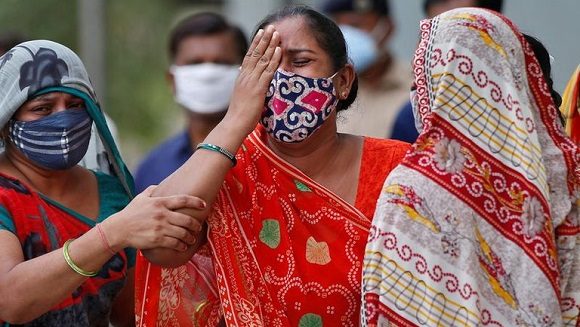 Una mujer llora tras la muerte de su marido a causa del COVID-19 a las puertas del depósito de cadáveres de un hospital en Ahmedabad, India. Foto: Reuters.