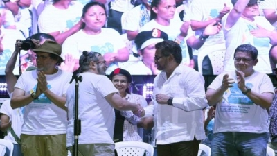 Timochenko" (2i) estrecha la mano de "Iván Márquez" (2d) tras la declaración política de la Décima Conferencia Nacional Guerrillera.